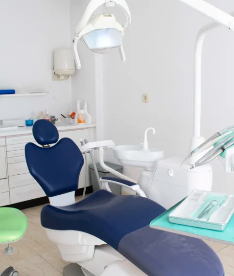 Gabinete dental equipado con sillón azul y lámpara de exploración - Clínica Dental Andrea Torres